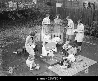 50 kleine Kinder unter fünf Jahren in der Romani-Kinderschule stellten den Schülern des Gypsy Hill Training College for Teachers of Young Children, Gypsy Hill, an dem es befestigt ist, Proben aus erster Hand zur Verfügung. Das College war das erste in Großbritannien, das die Ausbildung von Lehrern für Kindergärten. Kinder im Kindergarten können ein Baby baden, richtige Tischmanieren verwenden und kochen. Sie sollen am 10. November vor der Herzogin von Kent in der Stadt eine Ausstellung geben, um Geld für das College zu sammeln. Foto zeigt: Studenten der Hochschule studieren Kinder spielen. Die Spielsachen waren es Stockfoto