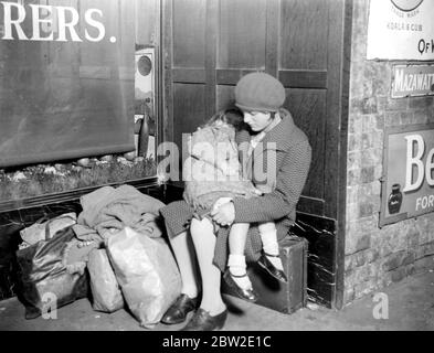 Müde Kinder warten am Bahnhof London Bridge auf einen Zug, um sie in Kent zu holen. 1933 Stockfoto