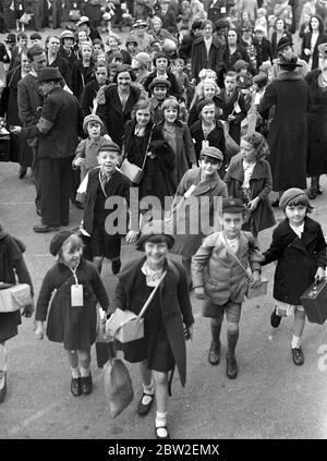 Kriegskrise, 1939. Luftangriff Vorsichtsmaßnahmen der zweite Weltkrieg begann und Evakuierten wie diese in diesem Bild, begann aus London für die Sicherheit des Landes zu gießen. Mit Gasmasken-Koffern, mit Gepäcketiketten, die sie an ihrer Kleidung festkleben - für einige von ihnen war es ein großes Abenteuer, für viele von ihnen hatten noch nie ihr Zuhause verlassen, oder sogar London zuvor. Foto zeigt ; Schulkinder von Middlesex Street warten auf Transport. September 1939 Stockfoto