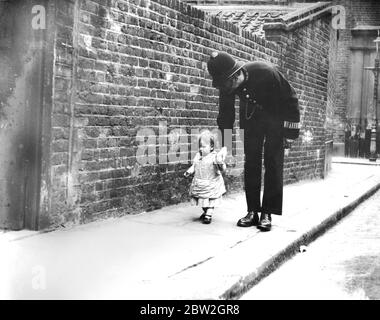 Kinder und Kleinkinder spielten auf der Straße, sogar ein Kind dieses Alters konnte draußen spielen dürfen, weg wandern und mit der Obhut des Polizisten auf dem Schlag zurückkommen. Stockfoto