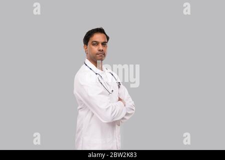 Indischer Mann Doktor Seroius Gesicht Hände Gekreuzt Isoliert. Gesundes Leben, Medizin Konzept. Stockfoto