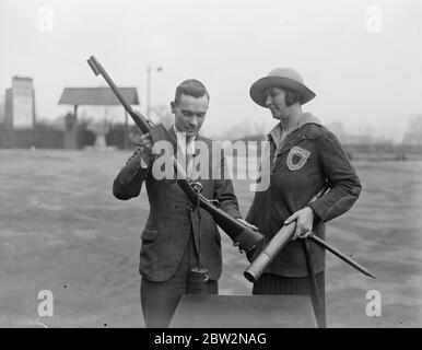 Das Bisley-Haus öffnet im Alexandra Palace. Die Gesellschaft der Miniture Rifle Clubs nationalen Indoor Bisley für kleine Bohrgewehre eröffnet am Alexandra Palace . Die zweitausend Teilnehmer kamen aus allen Teilen Britians. Foto zeigt, Frau Edyvean Walker mit dem Abzug ihres Gewehr von einem Beamten getestet, um sicherzustellen, dass es einen Druck von drei Windhunden hat. 14. April 1934 Stockfoto