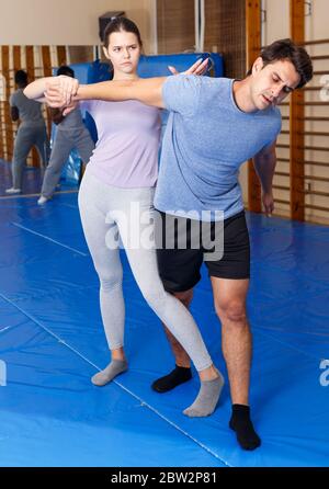 Junger Mann und Frau an selbstschutz Workout, training Angriff Bewegungen im Paar Stockfoto