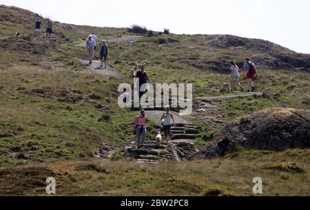 Wanderer üben soziale Distanz auf Dumyat in der Nähe von Stirling, wie Menschen können Familie und Freunde im Freien treffen und Sport wie Golf und Tennis wieder spielen, wie das Land in Phase eins der schottischen Regierung Plan für schrittweise Aufhebung der Sperre bewegt. Stockfoto