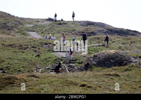 Wanderer üben soziale Distanz auf Dumyat in der Nähe von Stirling, wie Menschen können Familie und Freunde im Freien treffen und Sport wie Golf und Tennis wieder spielen, wie das Land in Phase eins der schottischen Regierung Plan für schrittweise Aufhebung der Sperre bewegt. Stockfoto