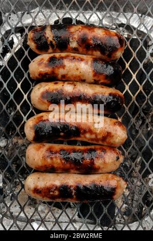 Würstchen auf einem Einweg-Grill Stockfoto