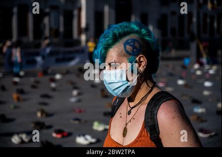 Madrid, Spanien. Mai 2020. Extinction Rebellion Aktivist protestiert während einer Performance, bei der mehr als 1000 Schuhe auf dem Sol Square auf dem Boden liegen, um Bürgerbeteiligung, soziale Gerechtigkeit und Maßnahmen gegen die Klimakrise und eine grüne Erholung nach der Coronavirus-Krise (COVID-19) zu fordern. Quelle: Marcos del Mazo/Alamy Live News Stockfoto