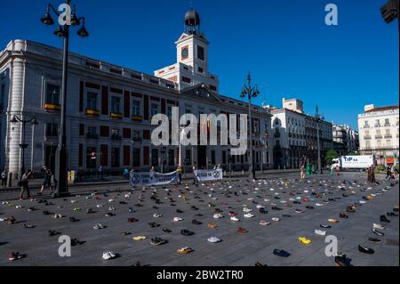 Madrid, Spanien. Mai 2020. Extinction Rebellion Aktivist protestiert während einer Performance, bei der mehr als 1000 Schuhe auf dem Sol Square auf dem Boden liegen, um Bürgerbeteiligung, soziale Gerechtigkeit und Maßnahmen gegen die Klimakrise und eine grüne Erholung nach der Coronavirus-Krise (COVID-19) zu fordern. Quelle: Marcos del Mazo/Alamy Live News Stockfoto