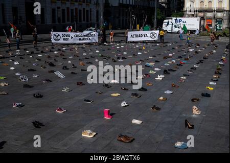 Madrid, Spanien. Mai 2020. Extinction Rebellion Aktivist protestiert während einer Performance, bei der mehr als 1000 Schuhe auf dem Sol Square auf dem Boden liegen, um Bürgerbeteiligung, soziale Gerechtigkeit und Maßnahmen gegen die Klimakrise und eine grüne Erholung nach der Coronavirus-Krise (COVID-19) zu fordern. Quelle: Marcos del Mazo/Alamy Live News Stockfoto