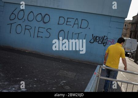 Glasgow, Großbritannien, 29. Mai 2020. Graffiti mit der Aufschrift '60,000 Dead, Tories Out!' Ist an einer Mauer im Stadtteil Govanhill der Stadt erschienen und zeigt lokale Wut über die Politik und den Umgang mit dem Coronavirus Covid-19 Gesundheitspandemie durch die konservative Regierung Großbritanniens unter der Leitung von Premierminister Boris Johnson. In Glasgow, Schottland, am 29. Mai 2020. Foto: Jeremy Sutton-Hibbert/Alamy Live News. Stockfoto