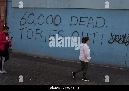 Glasgow, Großbritannien, 29. Mai 2020. Graffiti mit der Aufschrift '60,000 Dead, Tories Out!' Ist an einer Mauer im Stadtteil Govanhill der Stadt erschienen und zeigt lokale Wut über die Politik und den Umgang mit dem Coronavirus Covid-19 Gesundheitspandemie durch die konservative Regierung Großbritanniens unter der Leitung von Premierminister Boris Johnson. In Glasgow, Schottland, am 29. Mai 2020. Foto: Jeremy Sutton-Hibbert/Alamy Live News. Stockfoto