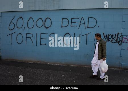 Glasgow, Großbritannien, 29. Mai 2020. Graffiti mit der Aufschrift '60,000 Dead, Tories Out!' Ist an einer Mauer im Stadtteil Govanhill der Stadt erschienen und zeigt lokale Wut über die Politik und den Umgang mit dem Coronavirus Covid-19 Gesundheitspandemie durch die konservative Regierung Großbritanniens unter der Leitung von Premierminister Boris Johnson. In Glasgow, Schottland, am 29. Mai 2020. Foto: Jeremy Sutton-Hibbert/Alamy Live News. Stockfoto