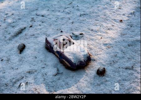 Verlassene oder verlorene Spielzeuge liegen auf dem Schnee. Konzept von Einsamkeit, Depression und Tod Stockfoto