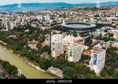 Blick über den Norden von Tiflis, der Hauptstadt Georgiens, in Richtung Dinamo Arena Stadion. Der Mtkvari Fluss fließt durch das Zentrum Stockfoto