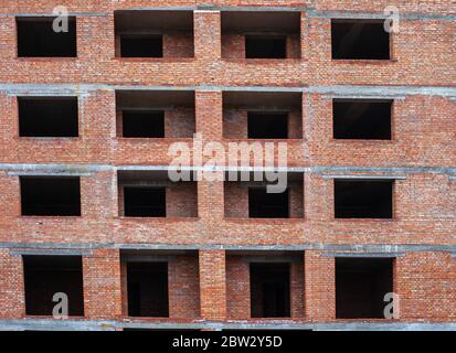 Leere Fenster in Backstein mehrstöckigen Haus im Bau. Teil der Eigentumswohnung Fassade Stockfoto