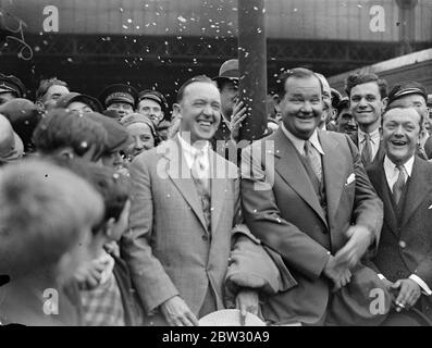 Laurel und Hardy in London. Stan Laurel, dessen richtiger Name Jefferson und sein amerikanischer Partner Oliver Hardy, der Filmkomödianten, sind in London am Waterloo Station, London, auf dem Aquitania-Bootszug angekommen. Stan Laurel und Oliver Hardy bei der Ankunft am Waterloo Station, London. 23 Juli 1932 Stockfoto