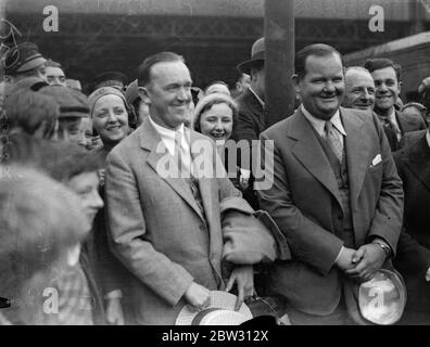 Laurel und Hardy in London. Stan Laurel, dessen richtiger Name Jefferson und sein amerikanischer Partner Oliver Hardy, der Filmkomödianten, sind in London am Waterloo Station, London, auf dem Aquitania-Bootszug angekommen. Stan Laurel und Oliver Hardy bei der Ankunft am Waterloo Station, London. 23 Juli 1932 Stockfoto