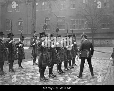 Ostersonntag Besichtigung der Beefeaters am Tower of London . Lieut Col Dan Burgess, VC Gouverneur des Tower of London inspizierte die Yoemen of the Guard, in ihren Tudor-Uniformen, im Innenhof des Turms, bevor sie am Ostersonntag Gottesdienst in St. Peter und Vinacular Church besuchen. Lieut Col Dan Burgess VC Gouverneur des Turms Inspektion der Beefeaters im Hof des Turms . 27 März 1932 Stockfoto