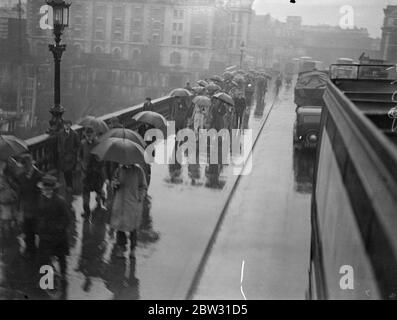 Der Regenschirm bedeckte die Menge der Arbeiter, die am Bahnhof Liverpool Street in London auf dem Weg zur Arbeit im Regen ankommen. September 1932 Stockfoto