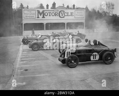 Rennen um British Empire Trophäe in Brooklands . Viele berühmte britische Rennfahrer Reihen sich am Start des British Racing Drivers Club , Empire Trophy Race , auf dem Brooklands Track , Weybridge , Surrey . Die Szene im Fahrerlager als die Autos zur Startlinie gingen. 30. April 1932 Stockfoto