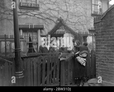 Prince of Wales im East End . Der Prinz von Wales besuchte arme Häuser im East End von London, um selbst zu sehen, wie die Armen in Slumland leben, in einem Haus, das er besuchte, Die von Frau Livesey in Park Place, Stratford, sie wasch ihre Füße am Kamin mit ihrem Baby auf dem Knie. Er besuchte auch das Haus von Herrn und Frau Easy und ihre Kinder, wo der Prinz bewunderte Blumen von Herrn Easy angebaut, der ein begeisterter Amateur-Gärtner ist. Herr und Frau Easy und die Kinder in ihrem Vorgarten, den der Prinz bewunderte, und mit Frau Livesey und ihrem Baby über den Besuch des Prinzen plauderten Stockfoto