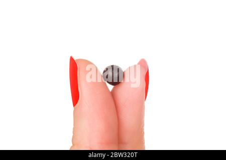 Chinesische Kräutermedizin Pille in Frau Finger isoliert auf weißem Hintergrund. Stockfoto