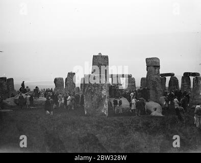 Die Menge sieht den Sonnenaufgang in Stonehenge am längsten Tag des Jahres. Eine Menge Leute versammelten sich in Stonehenge Autofahren in von Meilen um, um den Sonnenaufgang in Stonehenge bei Sonnenaufgang am 21. Juni zu beobachten, der längste Tag des Jahres. Der alte Aberglaube hat es, dass, wie die ersten Strahlen der aufgehenden Sonne den Altar berühren, was nur bei der Sommersonnenwende geschieht, das Blut der früheren Menschenopfer auf den Steinen gesehen werden kann. Ein Blick, der die Menge in Stonehenge bei Sonnenaufgang zeigt, um den Sonnenaufgang zu beobachten. 21 Juni 1932 Stockfoto