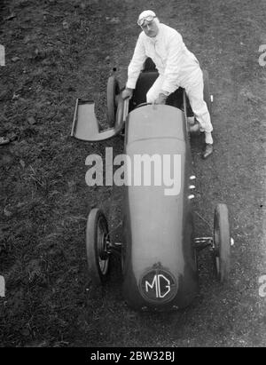 G E T Eyston bereitet sich auf Angriff auf Weltrekord für Baby-Autos in Pendine Sands . Herr G E T Eyston, der Rennfahrer, macht die letzten Vorbereitungen für seinen Versuch, einen neuen Weltrekord für Baby-Autos mit seinem MG The Magic Midget, die auf Pendine Sands, Carmarthenshire, Wales stattfinden wird. Er wird einen speziell angefertigten Asbestanzug tragen. Herr G E T Eyston trägt seine Asbestkleideranzug, Eingabe seines Autos durch Anheben der Windhaube, das Cockpit ist gemacht, um ihn zu passen, bevor das Auto seine Abingdon-Garage verlassen, Berkshire, für Pendine. Februar 1932 Stockfoto