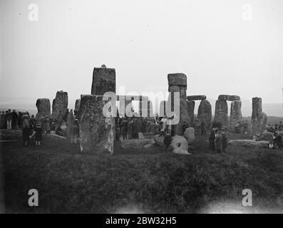 Die Menge sieht den Sonnenaufgang in Stonehenge am längsten Tag des Jahres. Eine Menge Leute versammelten sich in Stonehenge Autofahren in von Meilen um, um den Sonnenaufgang in Stonehenge bei Sonnenaufgang am 21. Juni zu beobachten, der längste Tag des Jahres. Der alte Aberglaube hat es, dass, wie die ersten Strahlen der aufgehenden Sonne den Altar berühren, was nur bei der Sommersonnenwende geschieht, das Blut der früheren Menschenopfer auf den Steinen gesehen werden kann. Ein Blick, der die Menge in Stonehenge bei Sonnenaufgang zeigt, um den Sonnenaufgang zu beobachten. 21 Juni 1932 Stockfoto