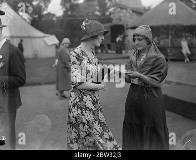 Lady Diana Cooper hat ihr Vermögen erzählt. Ein Palmist erzählt das Glück von Lady Diana Cooper auf der großen Country Fair in den Royal Botanical Gardens, Regents Park, London, die sie eröffnet. 30 Juli 1932 Stockfoto