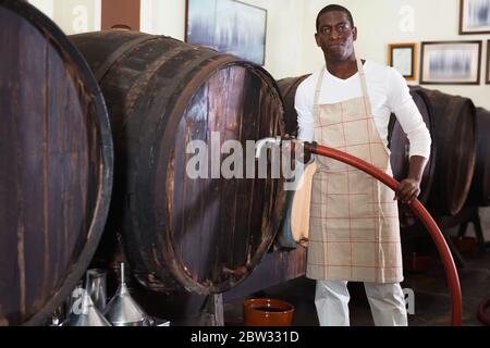 Fleißig fröhlich Weinproduzent Kontrolle der Produktion Wein in Weingut, Vorbereitung für die Weinfiltration Stockfoto