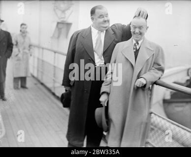 Laurel und Hardy kommen in Großbritannien auf der Queen Elizabeth. Oliver Hardy, der sperrige Hollywood-Filmkomödiant, und sein glum aussehender Partner Stan Laurel, kamen an Bord des Liners Queen Elizabeth in Southampton an. Dies ist ihr erster Besuch in Großbritannien seit 1932. Während ihres Besuchs werden sie auf Tour mit einem Skit namens Getting a Driving License gehen. Sie öffnen in Newcastle, gehen Sie weiter nach Birmingham, und dann zum Palladium in London. Es ist zwei Jahre her, dass Laurel und Hardy einen Film gedreht haben, sie sind in Vaudeville auf Tour und spielen Truppen. Stan Laurel (links) und Oliver Hardy (rechts Stockfoto