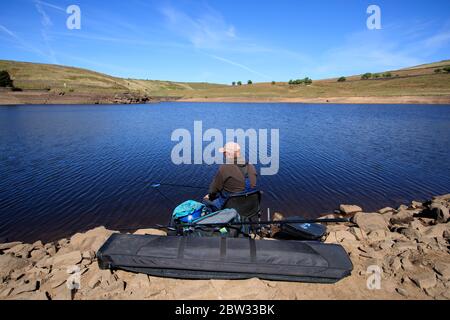 Ein Mann, der am Mitgiftreservoir in Oldham fischt, da einige Regionen auf Kurs für den trockensten Mai sind. Stockfoto