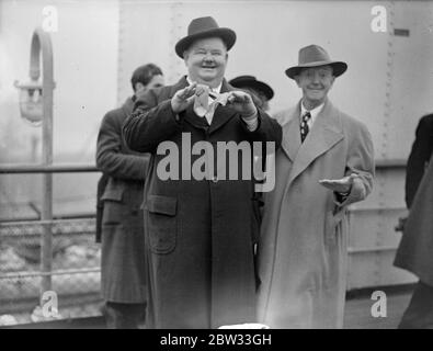 Laurel und Hardy kommen in Großbritannien auf der Queen Elizabeth. Oliver Hardy, der sperrige Hollywood-Filmkomödiant, und sein glum aussehender Partner Stan Laurel, kamen an Bord des Liners Queen Elizabeth in Southampton an. Dies ist ihr erster Besuch in Großbritannien seit 1932. Während ihres Besuchs werden sie auf Tour mit einem Skit namens Getting a Driving License gehen. Sie öffnen in Newcastle, gehen Sie weiter nach Birmingham, und dann zum Palladium in London. Es ist zwei Jahre her, dass Laurel und Hardy einen Film gedreht haben, sie sind in Vaudeville auf Tour und spielen Truppen. Stan Laurel (links) und Oliver Hardy (rechts Stockfoto