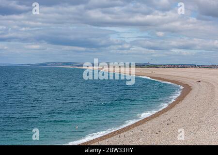 Blick auf den schönen Chesil Strand an einem warmen Sommermorgen mit mehreren Menschen in der Ferne genießen das sonnige Wetter Stockfoto