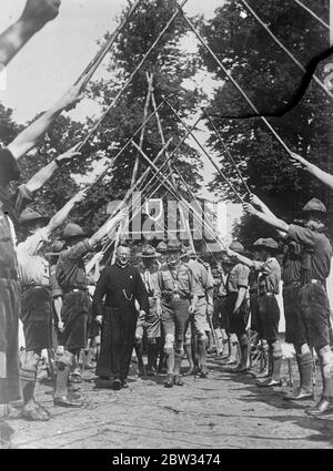 Lord Baden Powell in Holland . Lord Baden Powell, der Chef-Scout, stattete dem großen Pfadfinderlager in Wassenaar, in der Nähe von Den Haag, Holland, einen Besuch ab. Lord Baden Powell, begleitet von einem Bischof, Eingabe der römisch-katholischen Lager unter einem Torbogen von Pfadfindermasten während seines Besuchs. Bis 15. August 1932 Stockfoto