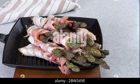 Frischer Spargel in Bacon eingewickelt bereit zum Grillen auf Eiserne Pfanne.. Stockfoto