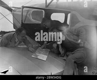 Vorbereitung der Prince of Wales Flugzeug für den König ' s Cup Air Race. Captain W L Hope (rechts) mit seinen beiden Passagieren in Brooklands, wo viele Piloten bereiten ihre Maschinen für die Kings Cup Air Race. Juli 1932 Stockfoto