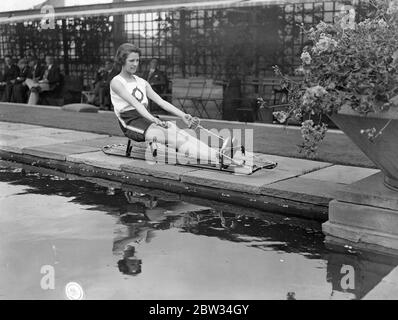 Vertreter der Olympischen Spiele übt zum Mittagessen auf dem Dach auf dem Geschäft. Miss Violet Webb , die gewählt wurde, um Großbritannien in den Hürden bei den Olympischen Spielen in Los Angeles vertreten , USA praktiziert jede Mittagsstunde auf dem Dach des Selfridges Store , wo sie beschäftigt ist . Miss Violet Webb in der Ausbildung auf einem sculling Trainer während ihrer Dach Mittagessen Stunde Praxis . 22 Juni 1932 Stockfoto