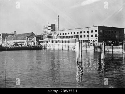 Tolle Station für den Bodensee. Ein neuer Bahnhof ist gerade in Friedrichshafen am Bodensee fertiggestellt. Der Bahnhof befindet sich am Ufer des Sees und somit können die Fahrgäste ihre Züge zu den Dampfschiffen, die den Dienst zwischen der deutschen und der Schweizer Küste betreiben, aussteigen. Ein Blick auf den neu fertiggestellten Bahnhof vom See in Friedrichshafen. Februar 1932 Stockfoto