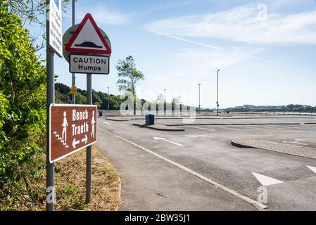 Ein Schild weist an einem sonnigen Frühlingsfeiertag während der 2020-Coronavirus-Krise von einem leeren Parkplatz auf Barry Island auf den Weg zum Strand. Stockfoto