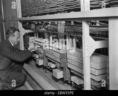 Prince of Wales zu überprüfen, internationale Telefonanlage . Der Prinz von Wales, der vom Oberbürgermeister von London, Sir Percy Greenaway und Sir Kingsley Wood, dem Postmaster General, empfangen wird, wird das Faraday-Gebäude, London, das große Telefonhauptquartier von Großbritannien und dem Empire, inspizieren. Nach seiner offiziellen Eröffnung des Oberbürgermeisters , morgen . Ein Ingenieur arbeitet an der großen internationalen Schalttafel in der Telefonzentrale im Faraday House, die der Prinz von Wales inspizieren wird. Mai 1933 Stockfoto