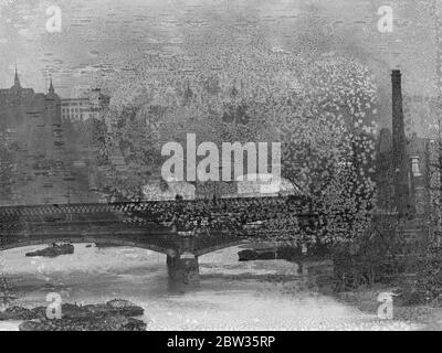 Lange Fokusansichten der Themse mit den Türmchen des Tower of London und Tower Hill und Bargen, die auf dem Fluss festgemacht sind. Mai 1933 Stockfoto