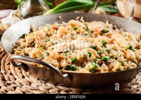 Gebratener Reis mit Garnelen und Gemüse auf einer Pfanne. Beliebtes chinesisches Gericht Stockfoto