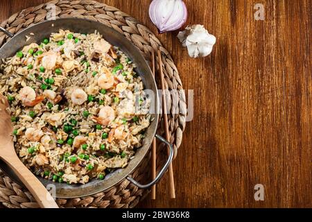Gebratener Reis mit Garnelen und Gemüse auf einer Pfanne. Beliebtes chinesisches Gericht. Draufsicht Stockfoto