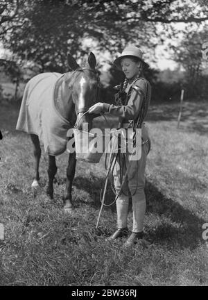 Füttern sie Mount in Westerham Hill montiert gymkhana . Die jährliche Pferdeshow und gymkhana in Hilfe des Royal Veterinary College London, fand in Westerham Hill, Kent, wenn es mehrere Veranstaltungen für Kinder. Foto zeigt, Hermine Bezzant Fütterung ihrer Mount "Sorbo", bei der Show. Bis 23. August 1933 Stockfoto