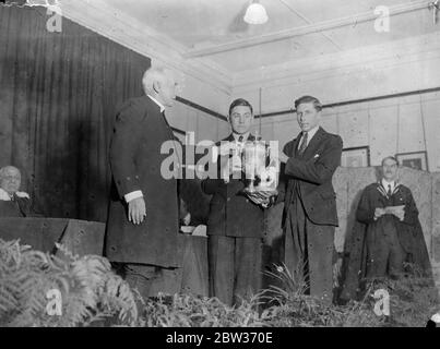 Bischof von London überreicht Preise in Hampton Grammer Schule. Der Bischof von London, Dr. Winnington Ingram, überreichte die Preise an der Hampton Grammer School, Middlesex. Foto zeigt ; der Bischof von London präsentiert den Heather Cup an P Hartwell von Walpole ' s House und D W Purdon von Papst ' s House . Der Cup wurde an die beiden Häuser für allgemeine Effizienz vergeben. Dezember 1933 Stockfoto