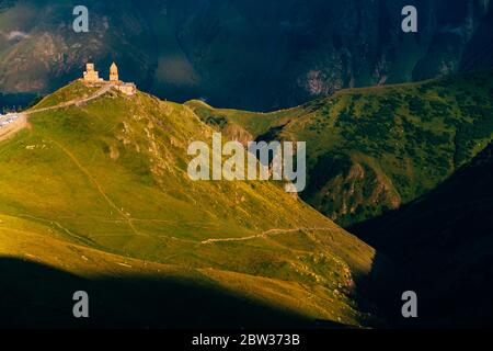 Die Gergeti Trinity Kirche bei Sonnenuntergang. Höhe 2170m, nahe Mount Kazbek, Georgia Stockfoto