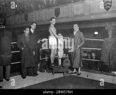 Watson und Crowley wiegen - in für großen Kampf . Seemann Watson, der britische Federgewichtsmeister, und Dave Crowley von Clerkenwell, wog im Stadium Club Holborn für den großen Kampf in Olympia ein. Foto zeigt ; Crowley ( auf Skalen ) Händeschütteln mit Seaman Watson , am Wiegen in . 19 Dezember 1933 Stockfoto