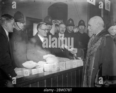 Bürgermeister von Shoreditch erhält erste Dividende von £ 30 , 000 Aktie - out . Die 42. Jahresaktie - aus der New Tabernacle Sick and Provident Society fand in der New Tabernacle Church , Old Street , London . Die £ 30 , 000 Fonds wurde von der Bank zur Kirche von einem Motorwagen und einem bewaffneten Wächter während des Verfahrens gehalten. Foto zeigt ; Bürgermeister von Shoreditch erhält die erste Dividende der £ 30 , 000 Aktie - out . 16 Dezember 1933 Stockfoto